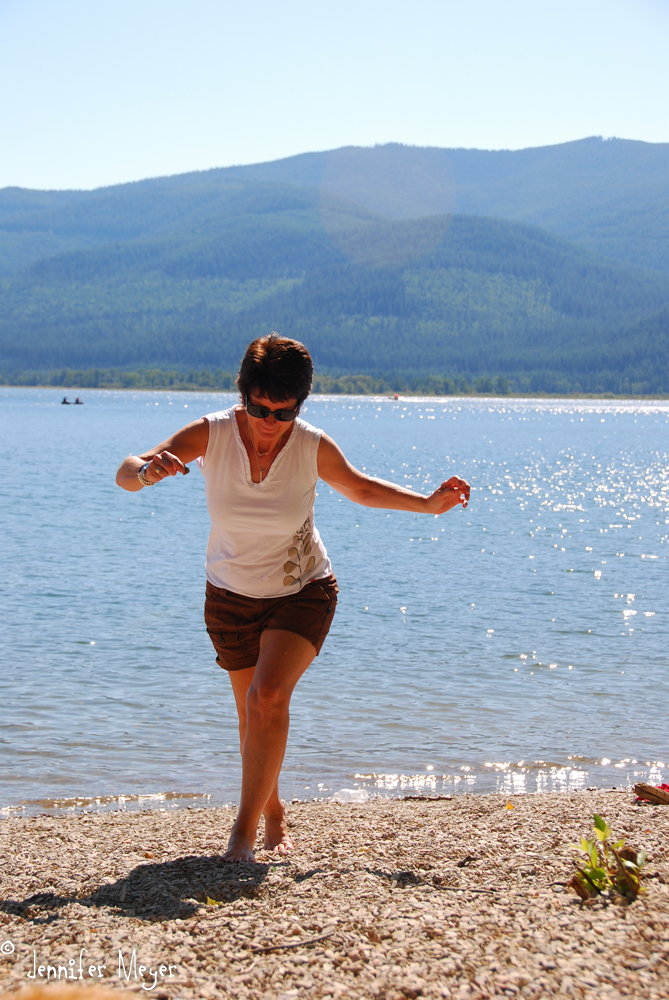 Kathy barefoot on the rocky beach.