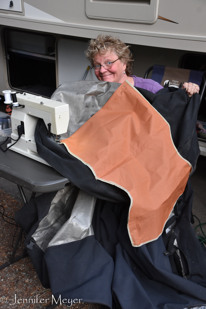 Kate repairs our bike cover with material from a discarded camp chair found in Arkansas.