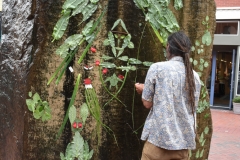 Artist working with leaves and a water wall.