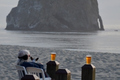 This woman and her dog were enjoying a cold beer on a cold evening.