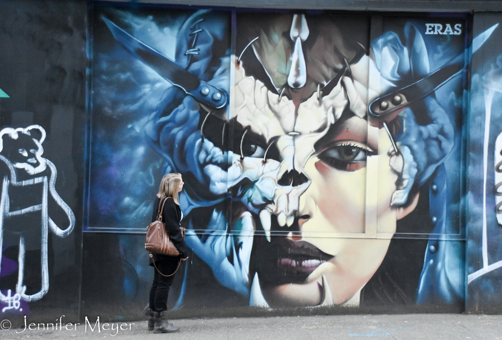 She studies a mural on her street.