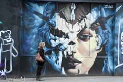 She studies a mural on her street.