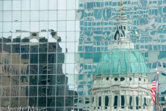 Old capitol reflected in a glass building.