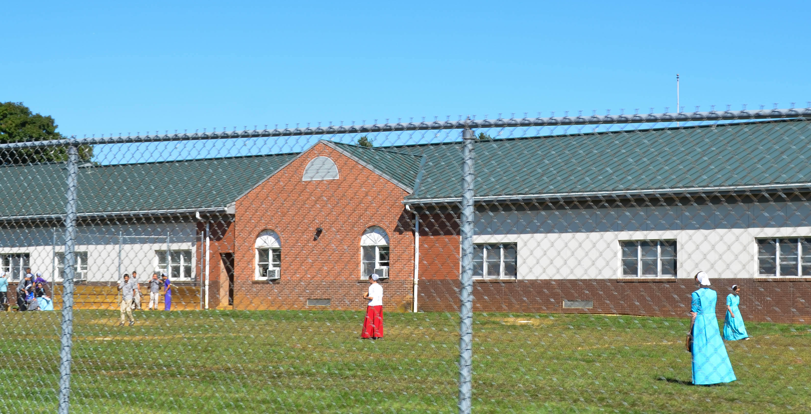 Some kids go to the town high school. Here they play softball.