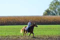A girl gallops in a field.