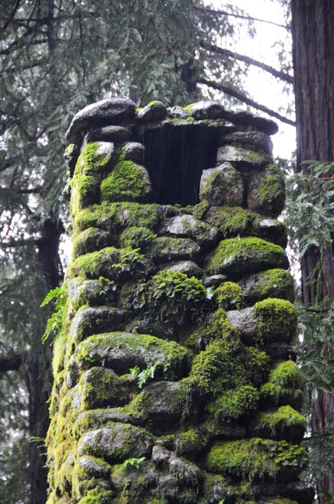 Stone chimney on the log building.