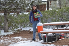 After the snow stopped and started to melt, Hilary came out to get the toaster for breakfast.