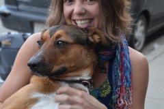 Young woman sitting on a bench cuddling her dog.