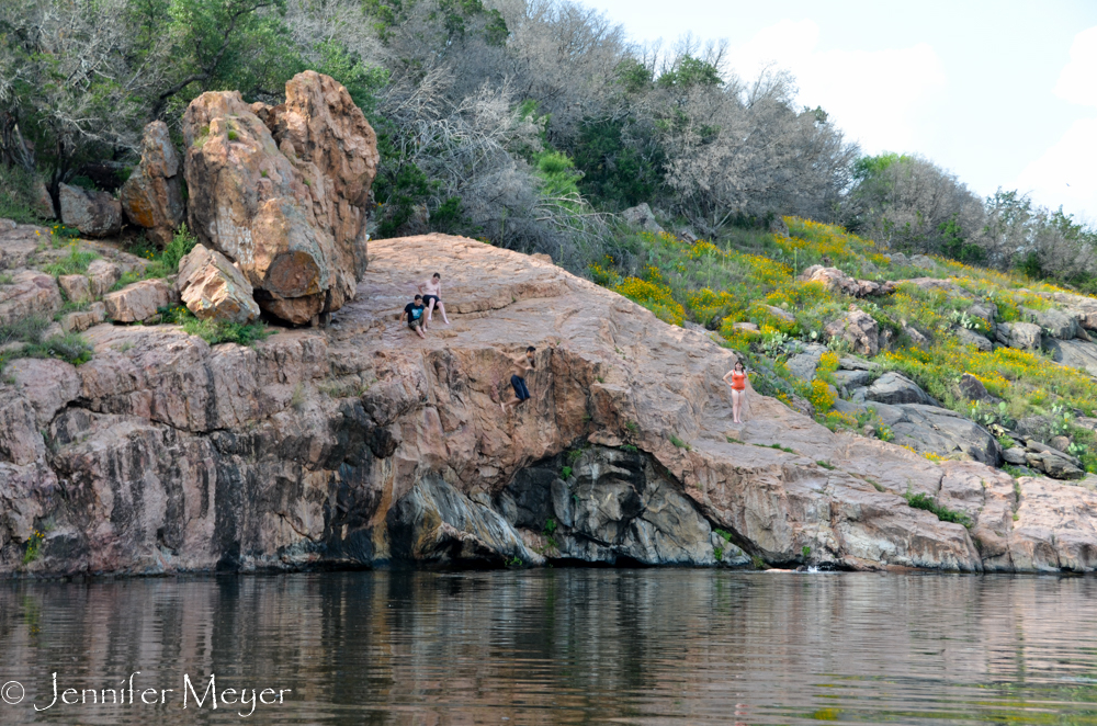 Kid jumping off rock into lake.