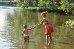 Alder's mom, Julie, shows him how to fish.