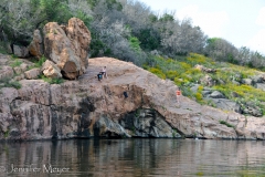 Kid jumping off rock into lake.