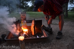 Don tries to build a campfire with wet wood and trash.