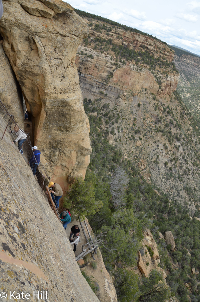 ...while using footholds in the rock to climb up the cliff.