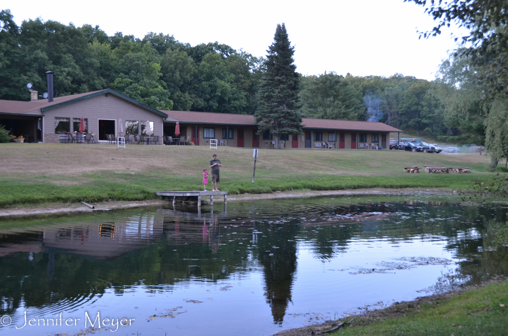 A father and daughter feed the fish.