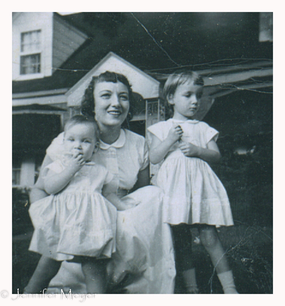 Mom with my sister and me in front of our grandmother's house.
