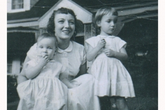 Mom with my sister and me in front of our grandmother's house.
