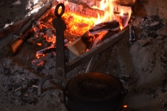 Applesauce is cooked in a bed of coals on the hearth.