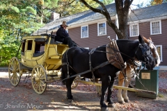 A stagecoach sits outside the tavern.