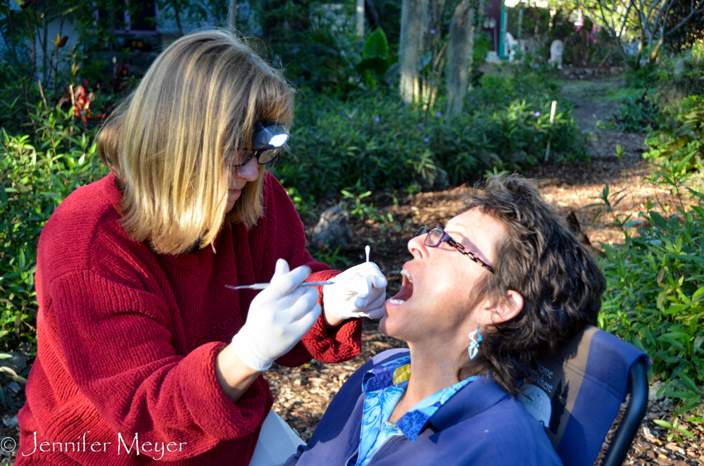 Tammy, a dental hygenist, installs a temporary filling for Julia.
