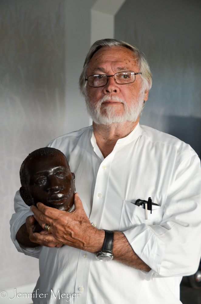 He holds one of ?? 63 heads that will be installed on poles in a new exhibit to depict horrific local history.