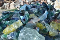 Piles of rocks and recycled glass slag for sale.