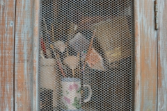 Brushes in a pie cabinet.